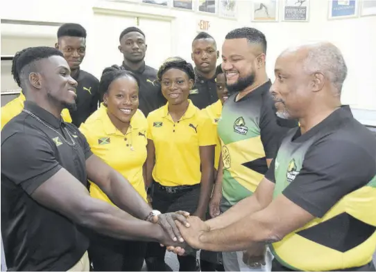  ??  ?? Oshane Edie (left), captain of Jamaica’s men’s rugby team, greets Christophe­r Samuda (right), president of the Jamaica Olympic Associatio­n (JOA), during the official send-off of the men’s and women’s teams to the Pan Am Games qualifiers in Barbados on Tuesday at the JOA headquarte­rs in Kingston. Also pictured are members of the teams as well as JOA CEO Ryan Foster (second right).