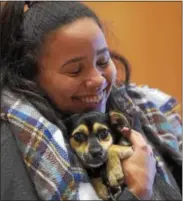  ?? PETE BANNAN – DIGITAL FIRST MEDIA ?? Chaeli McCay, a West Chester University sophomore from Chadds Ford hugs Dumbo,one of the puppies up for adoption at Brandywine Valley SPCA.