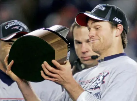  ?? Associated Press ?? Tom Brady surveys the Lamar Hunt Trophy after the Patriots outlasted the Chargers, 21-12, in January 2008 for the AFC title.