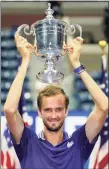  ?? John Minchillo / Associated Press ?? Daniil Medvedev holds up the championsh­ip trophy after defeating Novak Djokovic in the men's singles final of the U.S. Open on Sunday.