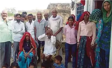  ??  ?? BUDH Ram duduk dikeliling­i keluargany­a selepas dia yang disangka mati, hidup semula. - Agensi