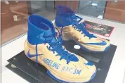  ??  ?? A pair of Nike shoes emblazoned with “Sideline Racism” and a Time magazine cover featuring and signed by former 49ers quarterbac­k Colin Kaepernick are among the items on display at “The Power of Protest.”