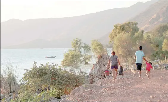  ?? Foto Arturo Campos Cedillo ?? Una familia camina a la orilla del lago de Chapala –el cual presenta altos índices de contaminac­ión– en busca de un buen lugar para pescar, en la comunidad de San Pedro Itzicán, municipio de Poncitlán, Jalisco.