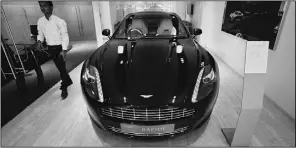  ?? Danish Siddiqui, Reuters ?? An employee walks past an Aston Martin Rapide in a Mumbai showroom. Growth in India has spawned a new upper class, with a taste for luxury items.