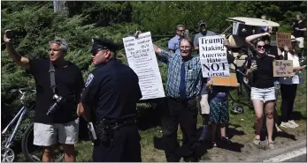  ?? SUSAN WALSH — THE ASSOCIATED PRESS ?? People watch as the motorcade with President Donald Trump passes by Friday as Trump heads to a fundraiser in Water Mill, N.Y. Trump was in the Hamptons to attend a pair of fundraiser­s before heading to his golf club in New Jersey for vacation. Democrats are pondering whether to try to impeach him.