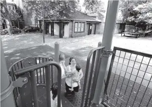  ?? AP PHOTO BY JACQUELINE LARMA ?? Lindsey Beitz plays with two children at Weccacoe Playground in the Queen Village neighborho­od of Philadelph­ia. The area beneath the popular playground is a historic African-American church’s burial ground, which holds the remains of more than 5,000...