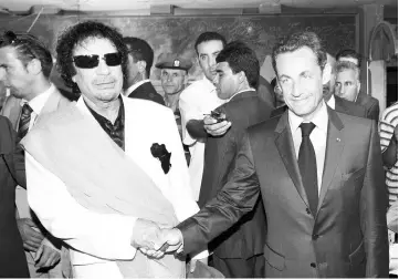  ??  ?? File photo shows Sarkozy shaking hands with Gaddafi (left) upon his arrival for an offcial visit to Libyain Tripoli. — AFP photo