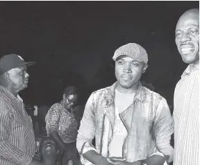  ??  ?? Deputy Commission­er George Quallo (left) and Commission­er of Police Dr. Carl Williams (right) join gospel artiste Kevin Downswell on stage during a gospel concert in Rose Town on the weekend, the concert was a call for peace.