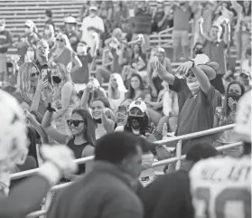  ?? ?? OU fans give the Horns Down gesture as Texas players walk past before the Red River Showdown last season.