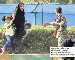  ??  ?? A woman takes her children to shelter during a shooting at a military parade in Ahvaz