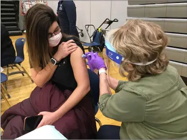  ?? PHOTOS BY RICHARD PAYERCHIN — THE MORNING JOURNAL ?? Spectrum School aide Kari Kincannon receives the first dose of the COVID-19vaccine from nurse Wendy Sikora at the mass vaccinatio­n clinic held Feb. 26, at Lorain High School.