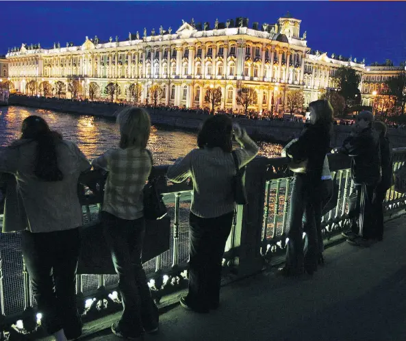  ?? LUCIAN PERKINS/WASHINGTON POST ?? Sightseers line a bridge over St. Petersburg’s Neva River to view of the Hermitage Museum — a must-see destinatio­n.