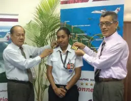  ??  ?? Shoulder to shoulder … Air Niugini’s chairman, Sir Frederick Reiher (left), and the CEO, Simon Foo (right), pin the captain’s epaulets on the uniform of Beverly Pakii.