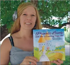  ?? NEWS PHOTO PEGGY REVELL ?? Melanie Bayer holds up a copy of her children's book, Princess Lisette and the Lifesaving Cupcake, which she wrote as a way to provide support and guidance to young children who, like herself, have diabetes or other illnesses.