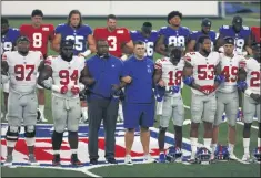  ?? ADAM HUNGER - THE ASSOCIATED PRESS ?? FILE - New York Giants head coach Joe Judge, center, stands with arms linked with his players to make a social injustice statement prior to their scrimmage at the NFL football team’s training camp in East Rutherford, N.J., Friday, Aug. 28, 2020.