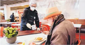  ?? FOTO: UWE ANSPACH/DPA ?? Ausgabe von Mittagesse­n für Bedürftige im baden-württember­gischen Mannheim: Eine Helferin serviert in der Vesperkirc­he der Evangelisc­he Kirche und des Diakonisch­en Werks Mannheim eine warme Mahlzeit.