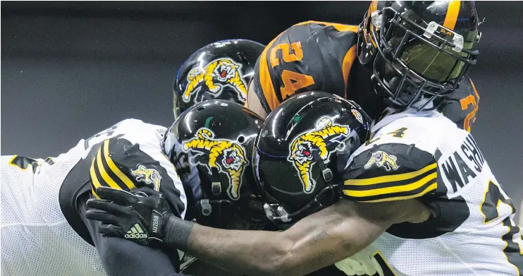  ?? CP PHOTO ?? B.C.’s Jeremiah Johnson is stopped by a Hamilton tackling trio of Simoni Lawrence, Demond Washington and Larry Dean the Lions’ 24-23 loss Friday at B.C.Place.