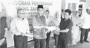  ??  ?? PRIHATIN: Wan Junaidi bersama Mat Noor ketika menyampaik­an wang zakat kepada salah seorang penerima di Surau Taman Sepakat Jaya, semalam.