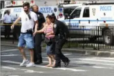  ?? MARY ALTAFFER — THE ASSOCIATED PRESS ?? Police help people cross the street outside the Bronx Lebanon Hospital in New York after a gunman opened fire there on Friday. The gunman, identified as Dr. Henry Bello who used to work at the hospital, returned with a rifle hidden under his white lab...