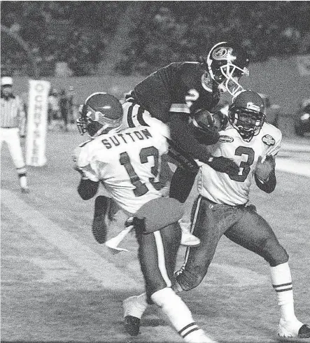  ?? PHOTO FILE ?? Doug flutie dives past Bryce Bevill and Eric Sutton for a touchdown in the second half of the 1997 Grey Cup in Edmonton.