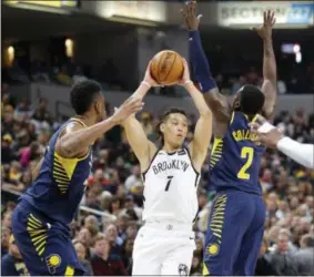  ?? MICHAEL CONROY — THE ASSOCIATED PRESS ?? Brooklyn Nets guard Jeremy Lin (7) makes a pass between Indiana Pacers forward Thaddeus Young (21) and guard Darren Collison (2) during the second half of an NBA basketball game in Indianapol­is, Wednesday. The Pacers defeated the Nets 140-131