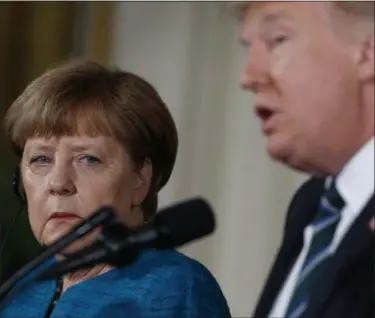  ?? EVAN VUCCI — THE ASSOCIATED PRESS ?? German Chancellor Angela Merkel listens as President Donald Trump speaks during their joint news conference in the East Room of the White House in Washington, on Friday.