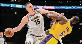  ?? Ashley Landis/Associated Press ?? Nuggets center Nikola Jokic (15) collides with the Lakers’ LeBron James in the second half of Game 4 of the NBA Western Conference Finals.