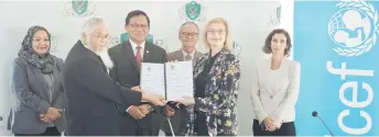  ?? — Photo by Chimon Upon ?? Khaidir (second left) and Saranovic exchange documents after signing the MoU at the DBKU headquarte­rs. Also seen are Dr Abdul Rahman (third left), Noriah (left), Junaidi (third right) and Dr Juanita (right).