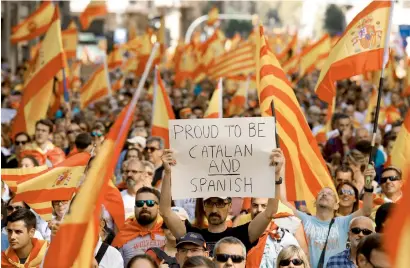  ?? Reuters ?? A man holds up a sign while attending a pro-union protest organised by the Catalan Civil Society organisati­on in Barcelona. —