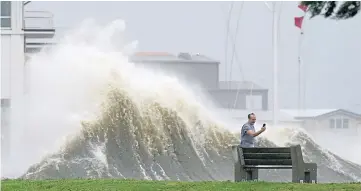  ??  ?? A man takes pictures at Lake Ponchartra­in as Hurricane Ida nears.