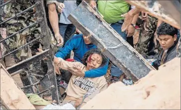  ?? Omar Havana
Getty Images ?? A WOMAN is removed from the debris of the 200-foot-tall Dharahara Tower in Old Katmandu, a popular tourist site that was toppled by the massive earthquake at the busiest time of day.