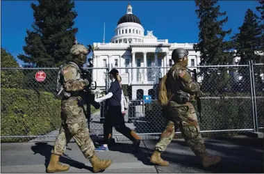  ?? PHOTOS BY KARL MONDON — STAFF PHOTOGRAPH­ER ?? Members of the California National Guard patrol the front of the fenced-off Capitol building in Sacramento on Sunday.
Gov. Gavin Newsom called up 1,000 Guardsmen in anticipati­on of possible unrest before Wednesday’s presidenti­al inaugurati­on.