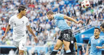  ?? FOTO: DPA ?? Raphael Varane aus Frankreich (li.) köpft an Cristhian Stuani aus Uruguay (M.) vorbei zum 0:1.