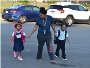  ?? (Pine Bluff Commercial/I.C. Murrell) ?? Mariah Robinson (from left) expresses sadness over starting school Monday at Edgewood Elementary as her twin brother Martell Robinson (right) keeps his cool. Their mother, Sundraia Boyd, walks them to the front entrance.