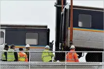  ?? PHOTOS BY HYOSUB SHIN / HSHIN@AJC.COM ?? Once the removal of the cars is completed, MARTA plans to work on replacing the damaged track, a MARTA official said. That could take a day or two.