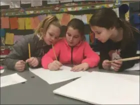  ?? ZACHARY SRNIS — THE MORNING JOURNAL ?? Avery Lambert, left, Khloe Minnich and Dannitza Moran, all 9-year-old fourth- graders, work on the dimensions of their gingerbrea­d house.