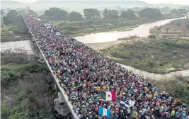  ??  ?? AFP / GETTY IMAGES EN MASSE: Honduran migrants, above, in a caravan headed to the U.S. leave Arriaga, Mexico, yesterday. Migrants climb atop a truck, right, as the caravan continues its slow march toward the U.S. border, outside Arriaga yesterday.