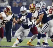  ?? RON JENKINS — THE ASSOCIATED PRESS ?? Cowboys running back Ezekiel Elliott (21) runs for a first down through a gap provided by Cowboys’ Travis Frederick (72) as Washington Redskins inside linebacker Will Compton (51) pursues in the second half Thursday in Arlington, Texas.