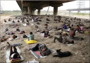  ?? ?? The Associated Press
Homeless people sleep in the shade of an overpass in New Delhi, India, on May 20. The Indian capital and surroundin­g areas reached highs of 49 C during a heat wave earlier this year.