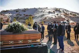  ?? Paul Ratje / AFP via Getty Images ?? Family and friends attend the funeral of Humberto Rosales, a caregiver who died at age 49 from COVID-19 complicati­ons, in Santa Teresa, N.M.