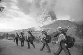  ?? Ringo H. W. Chiu, The Associated Press ?? Firefighte­rs march toward the El Dorado fire Sept. 5 in Yucaipa, Calif. Firefighte­rs trying to contain the massive wildfires in Oregon, California and Washington state are on the verge of exhaustion.