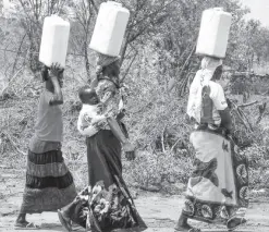  ??  ?? WOMEN from South Sudan fetch water far from home, similar to the plight of women in the hinterland­s of the Philippine­s without access to potable water near their homes.