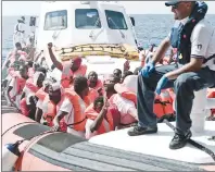  ?? AP PHOTO ?? In this photo released Wednesday by French NGO “SOS Mediterran­ee” shows migrants waving after being transferre­d from the Aquarius ship to Italian Coast Guard boats, in the Mediterran­ean Sea.