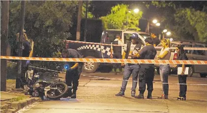  ?? MARIO SAYES ?? Pericias. La Policía, el martes a la noche, al lado de la moto del agente asesinado en San Martín.