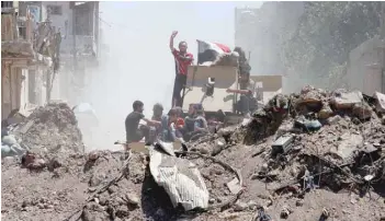  ??  ?? Displaced people who flee from the clashes ride in a military vehicle of Iraqi security forces, in the Old City of Mosul, Iraq, on Saturday.