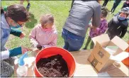  ?? DAN SOKIL — MEDIANEWS GROUP ?? York Avenue Elementary School kindergart­ners receive seeds and water from older students and parents as part of a lesson on how to take care of plants for Earth Day.