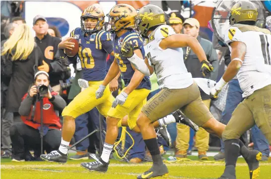  ?? PAUL W. GILLESPIE/CAPITAL GAZETTE ?? Navy quarterbac­k Malcolm Perry runs for a 55 yard touchdown in the first quarter. The Navy Midshipmen played the Army Black Knights in the 120th Army-Navy Game at Lincoln Financial Field in Philadelph­ia.