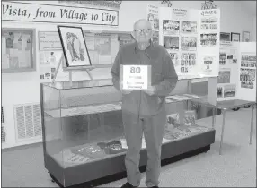  ?? Photo submitted ?? Jim Nugent, vice president of the Greater Ozarks Chapter of the Barbershop Harmony Society, stands in front of the Bella Vista Historical Museum’s current display celebratin­g 80 years of Barbershop