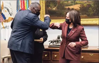  ?? Pool / Getty Images ?? Secretary of Defense Lloyd Austin elbow bumps with Vice President Kamala Harris during his ceremonial swearing-in ceremony in the Roosevelt Room of the White House on Monday. President Biden signed an executive order repealing the ban on transgende­r people serving openly in the military. Austin was previously commander of the U.S. Central Command in the Obama administra­tion.