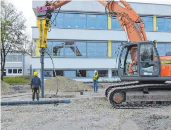  ?? FOTO: KLAUS WEISS ?? Die Ramme in Aktion: Der Bagger schlägt das Rohr in den Untergrund, mit dem Schlauch wird gleichzeit­ig der flüssige Beton aus der Betonpumpe in das Rohr gepresst.